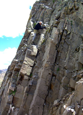 Jennifer downclimbing the Class 3 wall into the deep notch between the second false summit and the summit