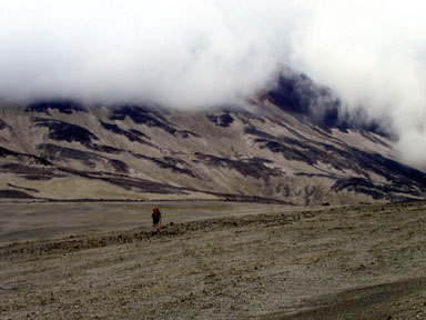 Rick Trujillo striding toward the still-huge upper mountain