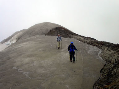 Brad and Chad Alber striding toward the summit along the outer crater's rim